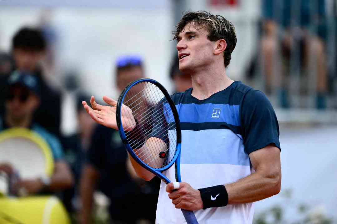 Jack Draper holding his racket and smiling after winning his fourth round match at the Italian Open