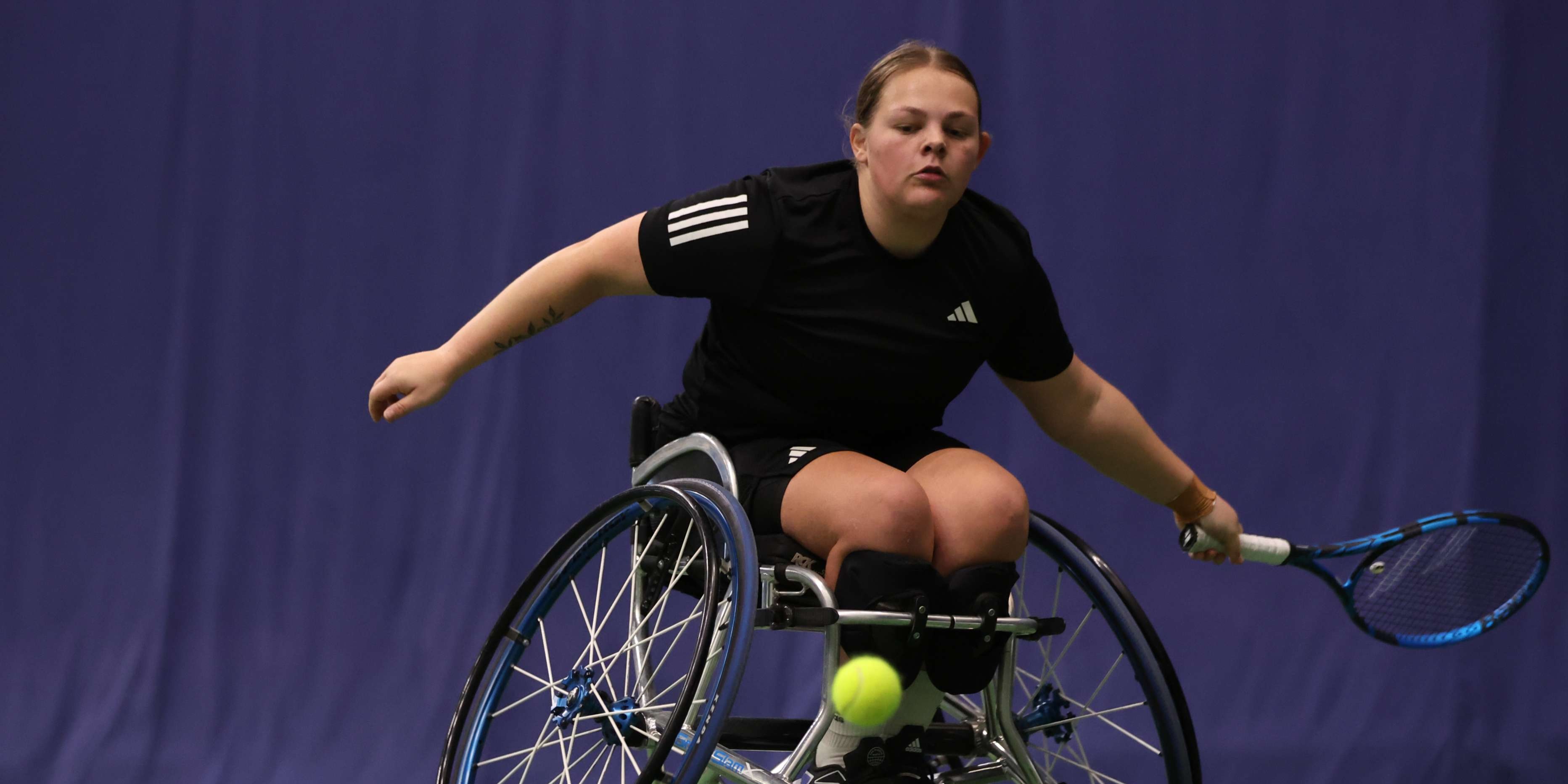 Wheelchair tennis player Ruby Bishop sat in her wheelchair while preparing to hit a forehand on court