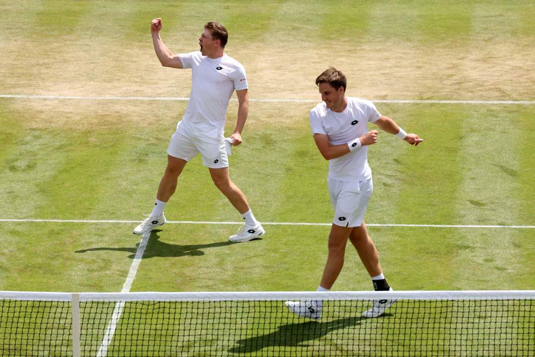Henry Patten and Harri Heliovaara celebrating on the grass court after a win in the Wimbledon quarter-final