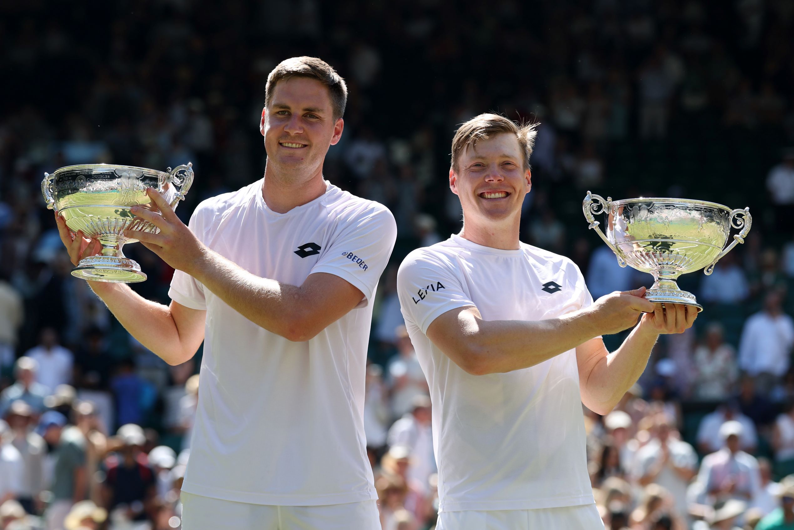 Henry Patten and Harri Heliovaara lift the men's doubles trophies at Wimbledon