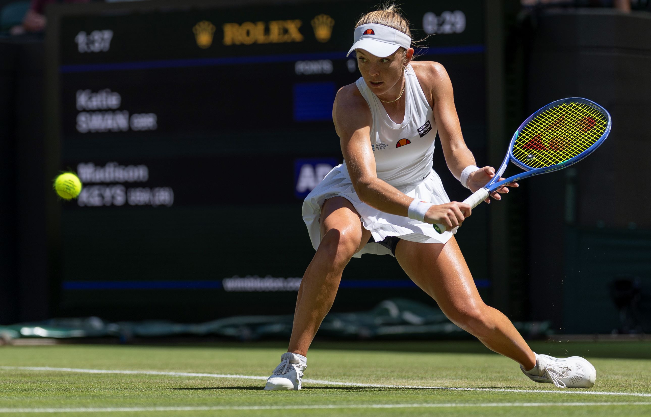 Katie Swan crouches down to hit a low ball on Court 1 at WImbledon