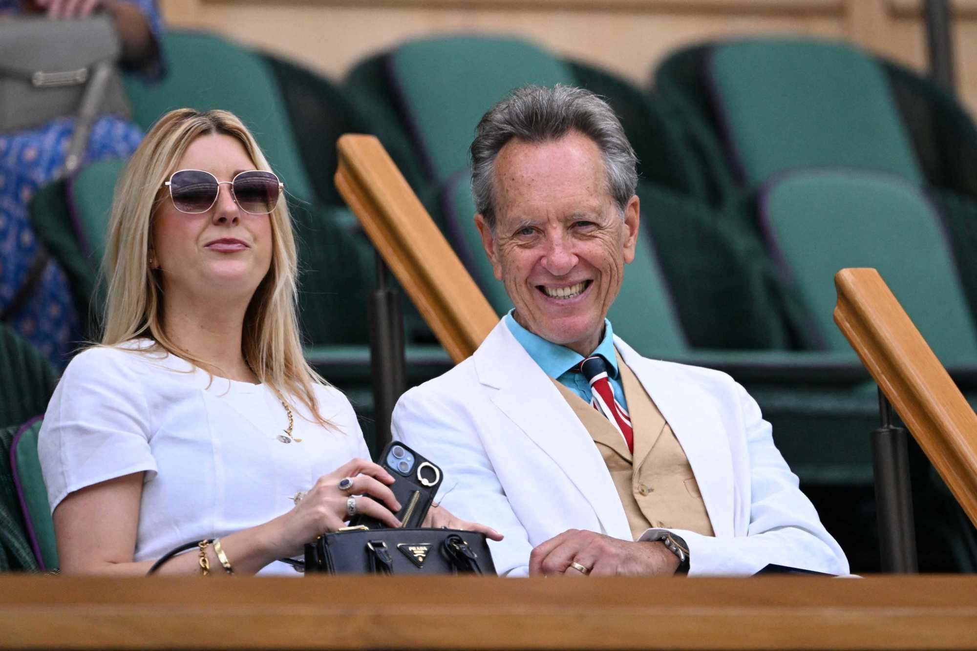Actor Richard E Grant smiling in the Royal Box while watching on with his daughter 