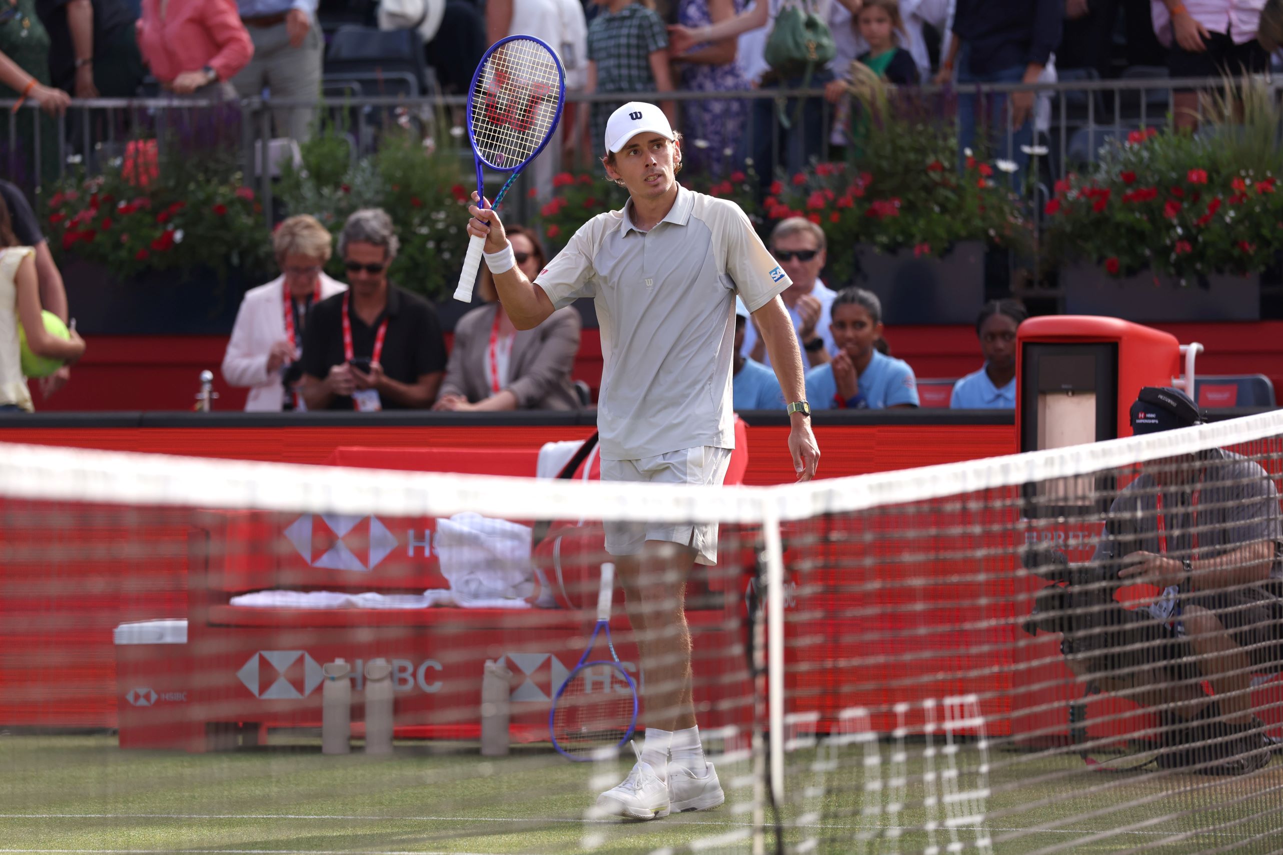 Alex de Minaur raising his racket in celebration after his first round win at the HSBC Championships