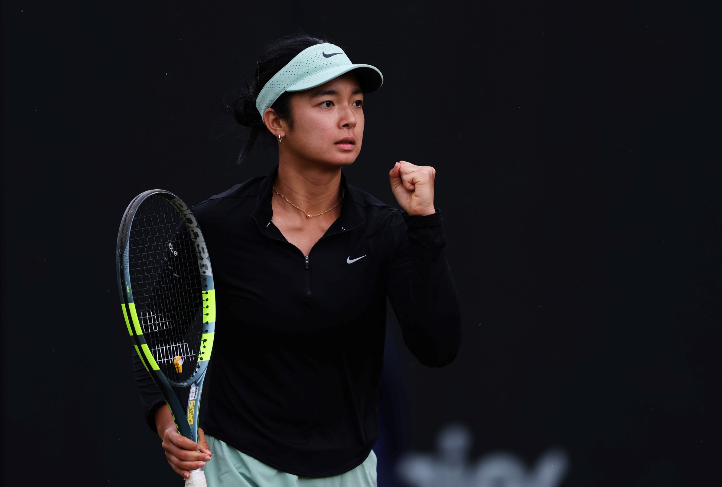 Tennis player Alexandra Eala raising her fist in celebration with her racket in her other hand after winning a point at the Lexus Birmingham Open