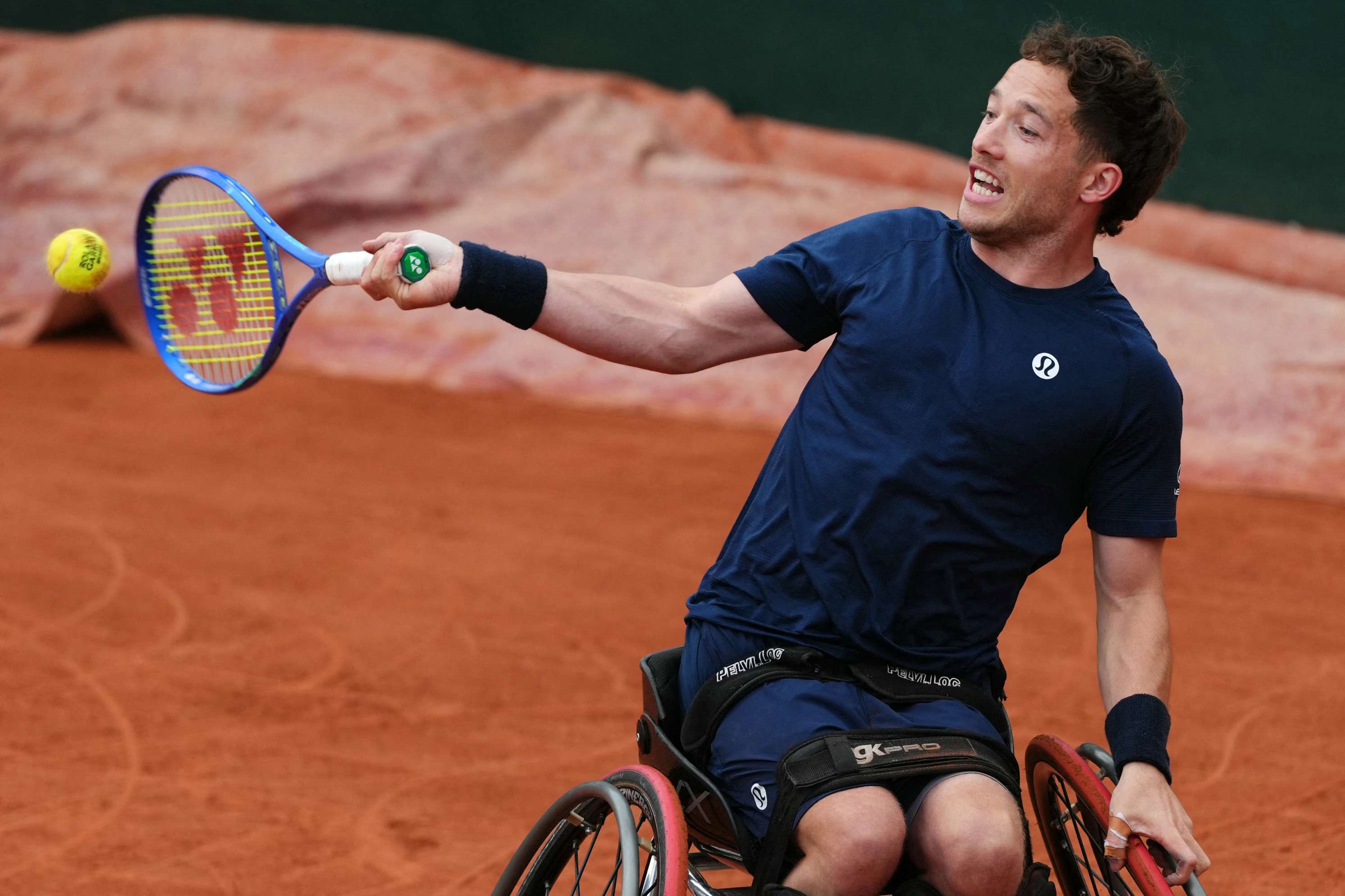 Wheelchair tennis player Alfie Hewett hitting a forehand on the clay courts at Roland Garros