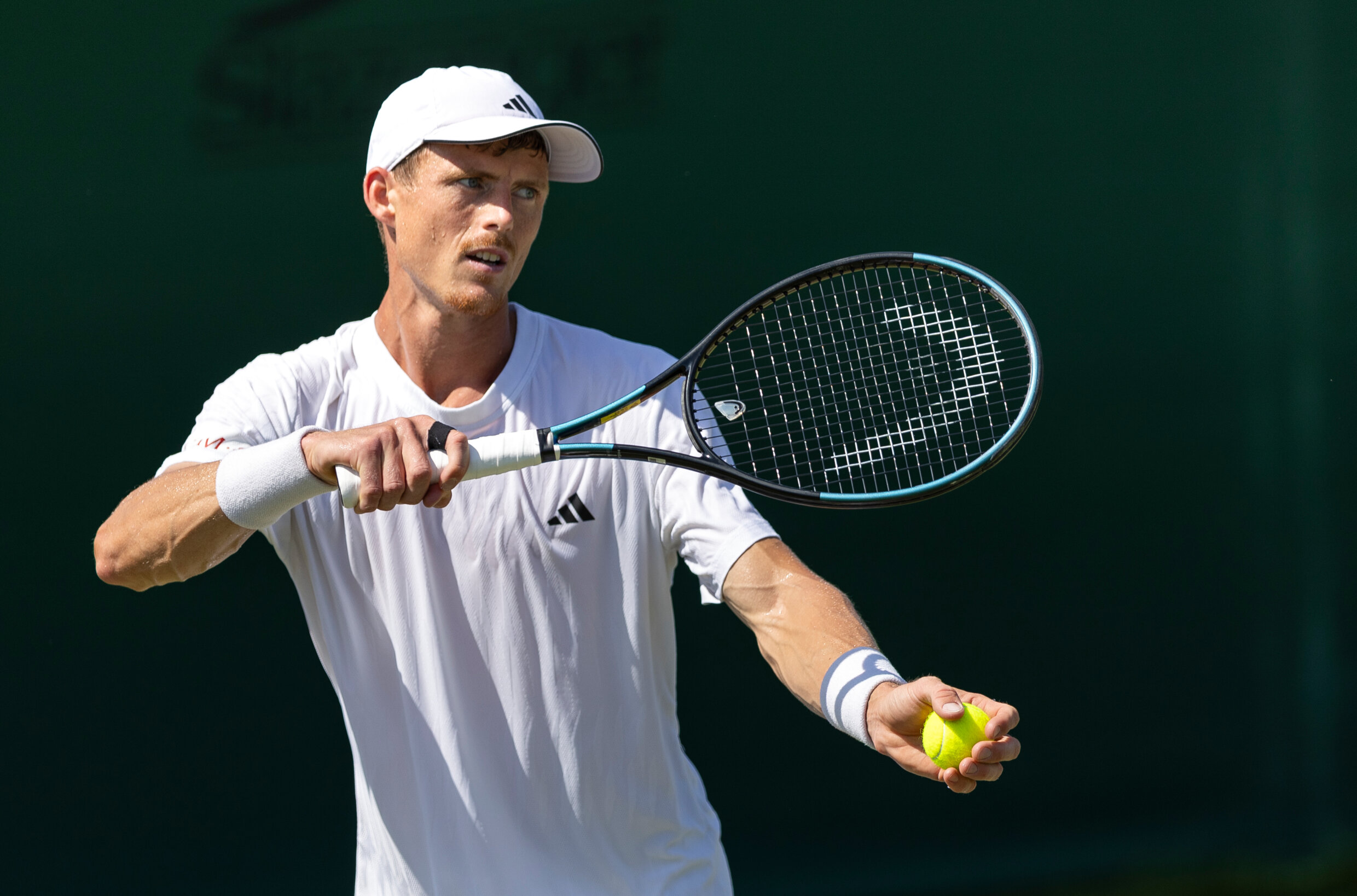 Billy Harris preparing to hit a serve on court at Wimbledon qualifying