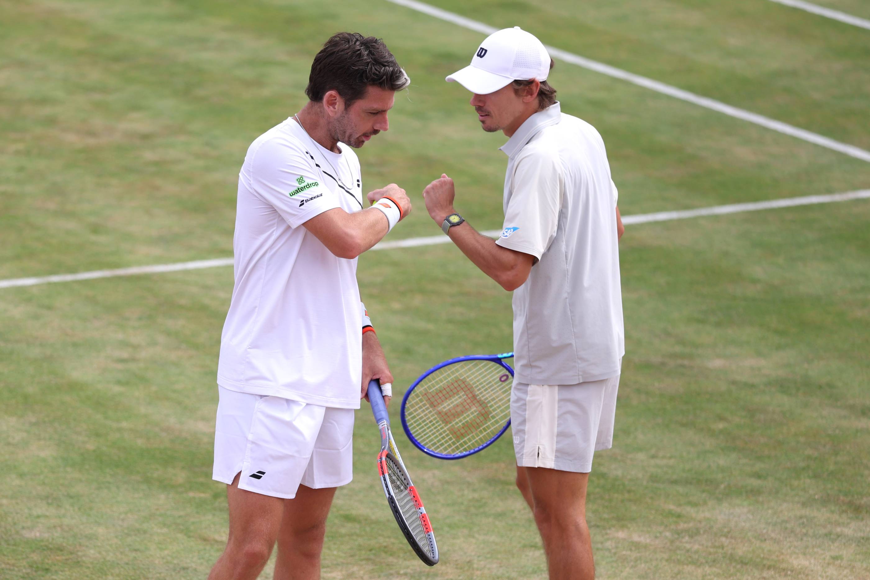 Cam Norrie and Alex de Minaur giving each other a fist bump on court at the HSBC Championships 