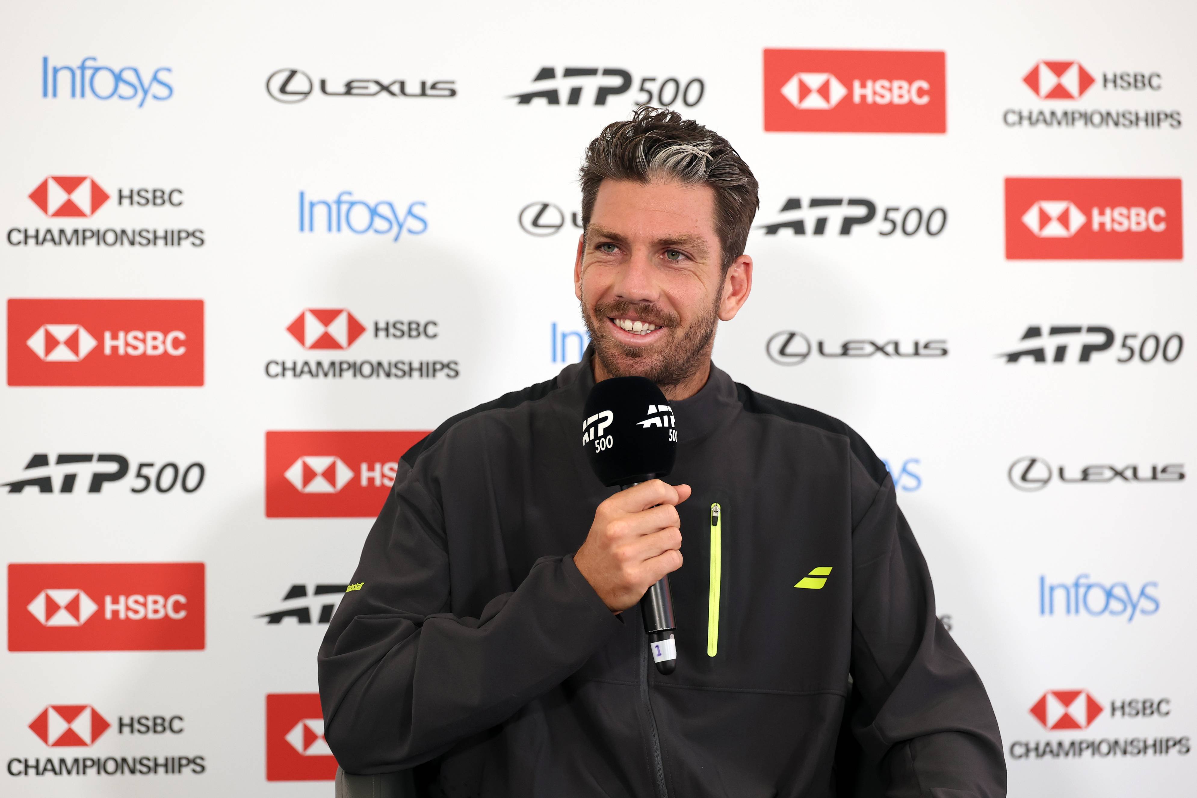 Cam Norrie holding a microphone during a press conference at the HSBC Championships