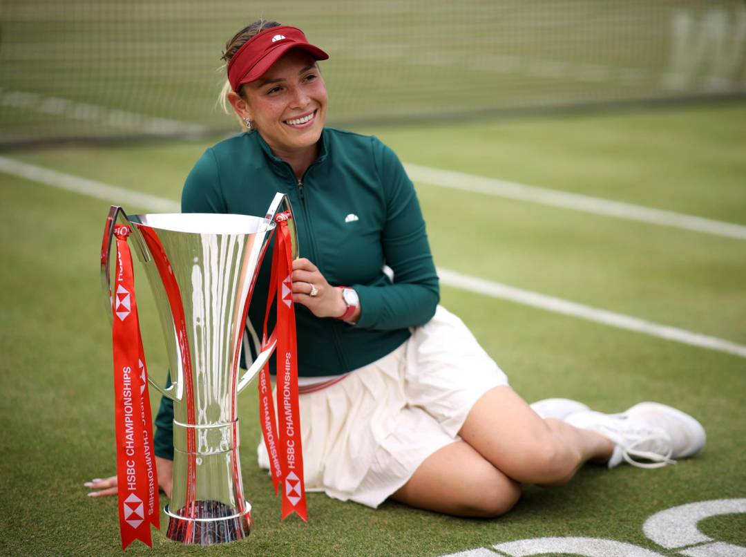 Donna Vekic sat on court at the Queen's Club, smiling while holding the HSBC Championships trophy