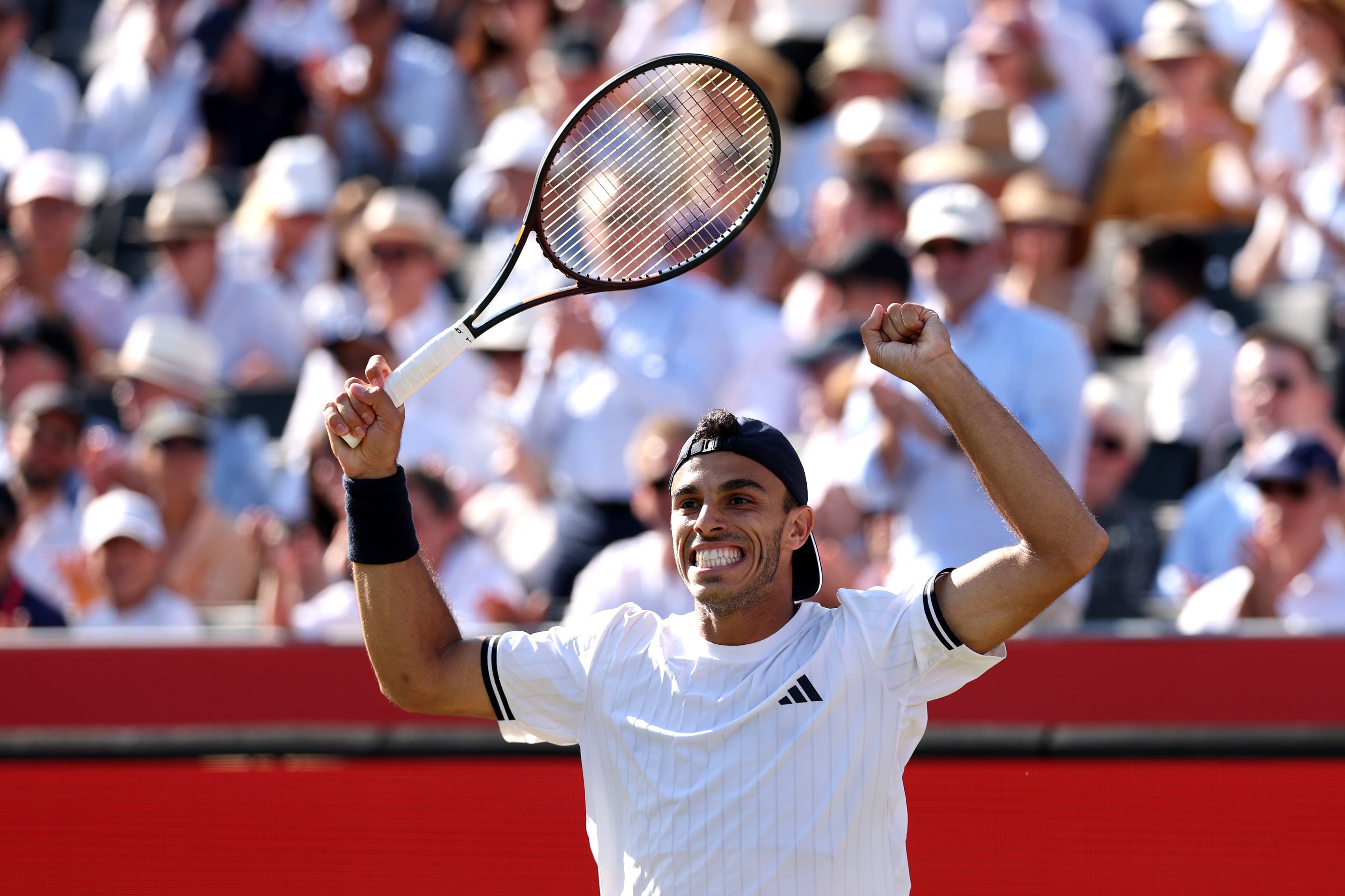 Francisco Cerundolo holding his arms up in the air and holding his tennis racket after winning his quarter-final match at the HSBC Championships