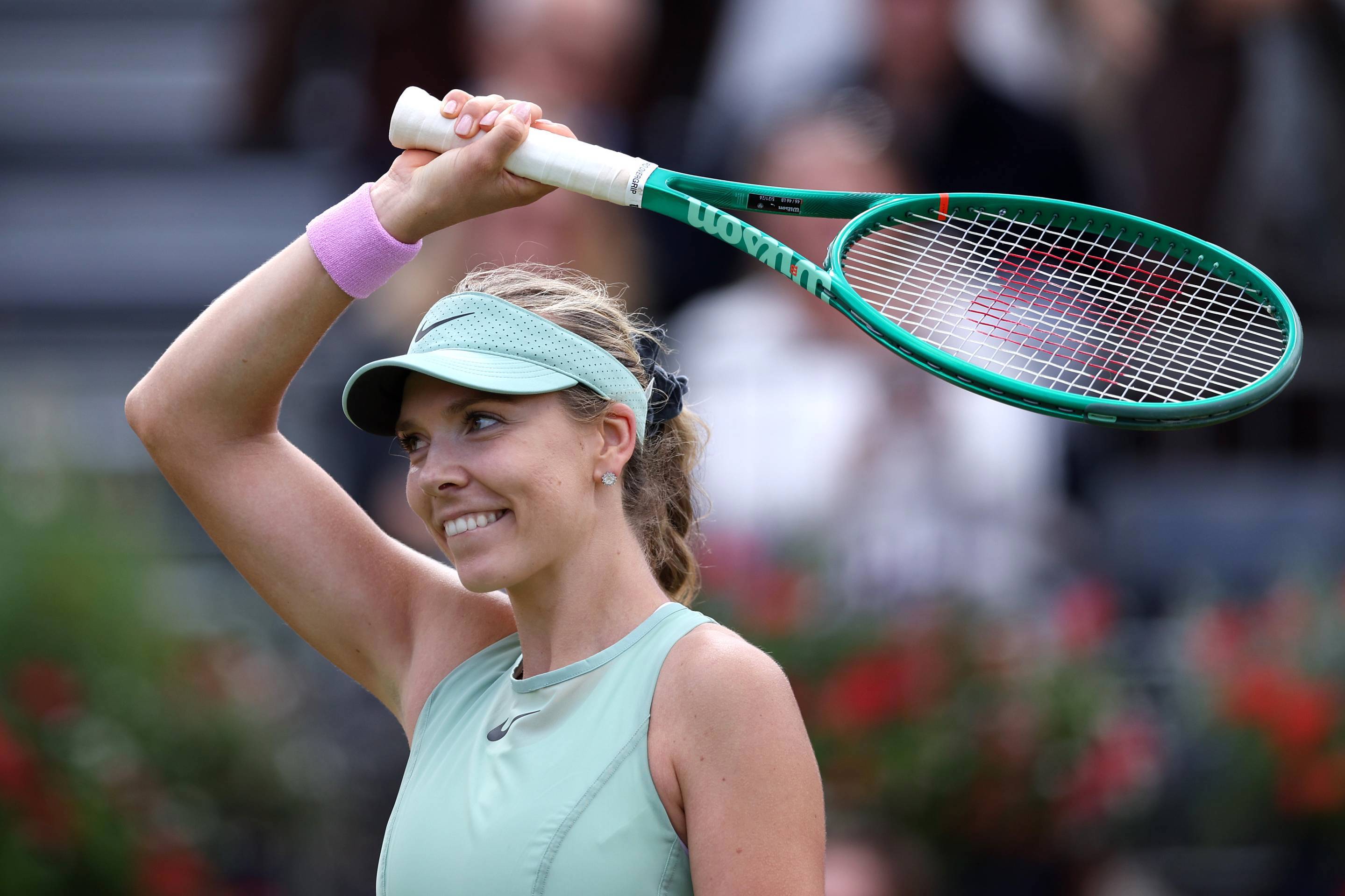 Katie Boulter waves her racket to the crowd after winning in the first round of the HSBC Championships