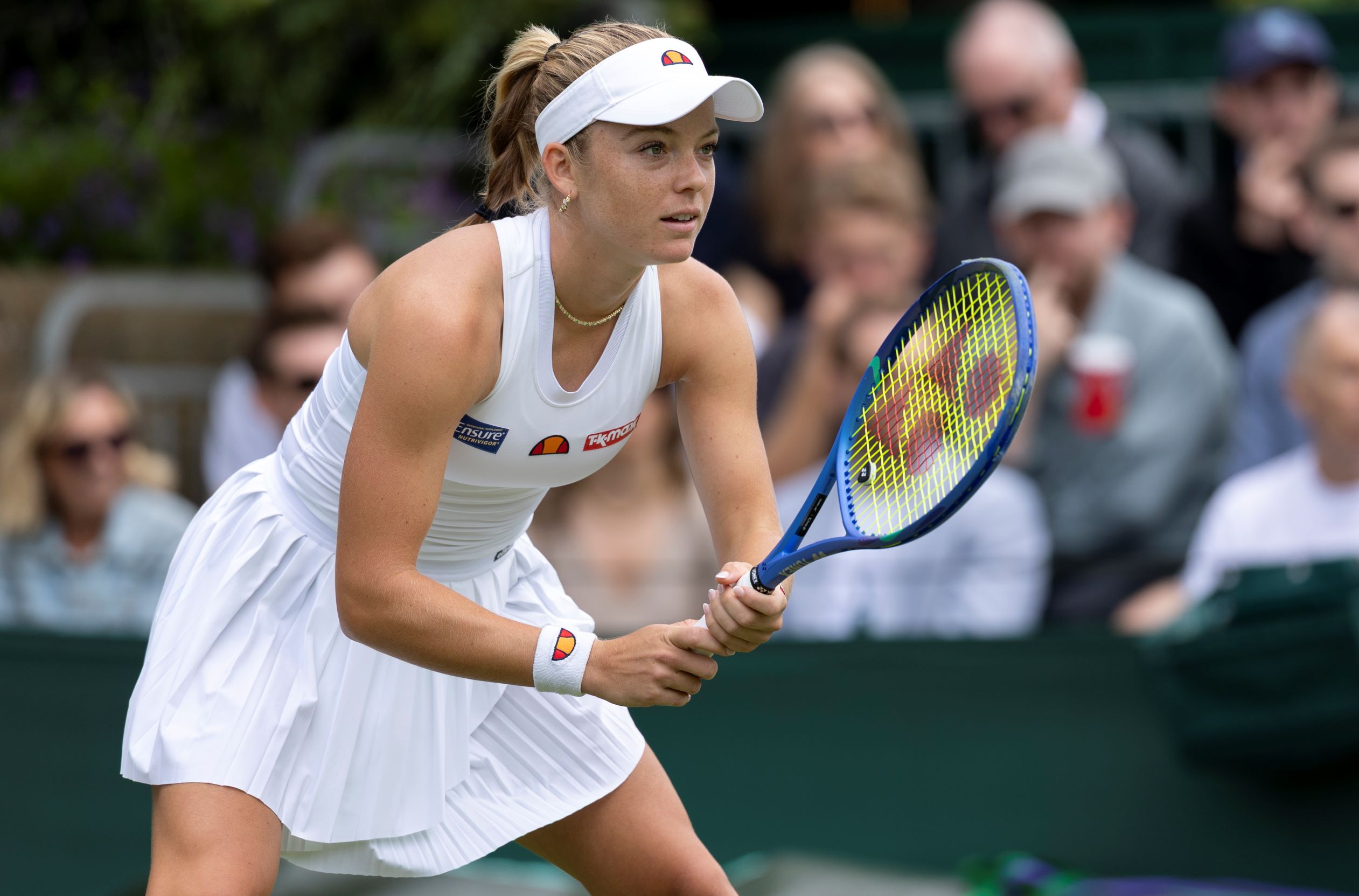 Katie Swan holding her racket out in front, preparing to receive a serve