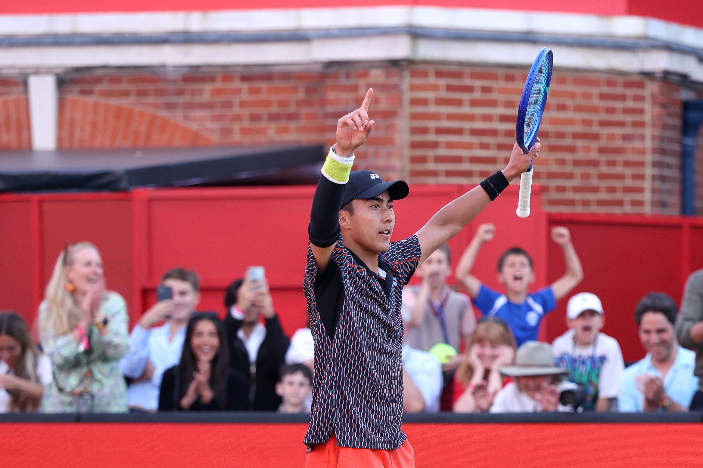Rinky Hijikata raising his arms in celebration after winning his second round match at The Queen's Club