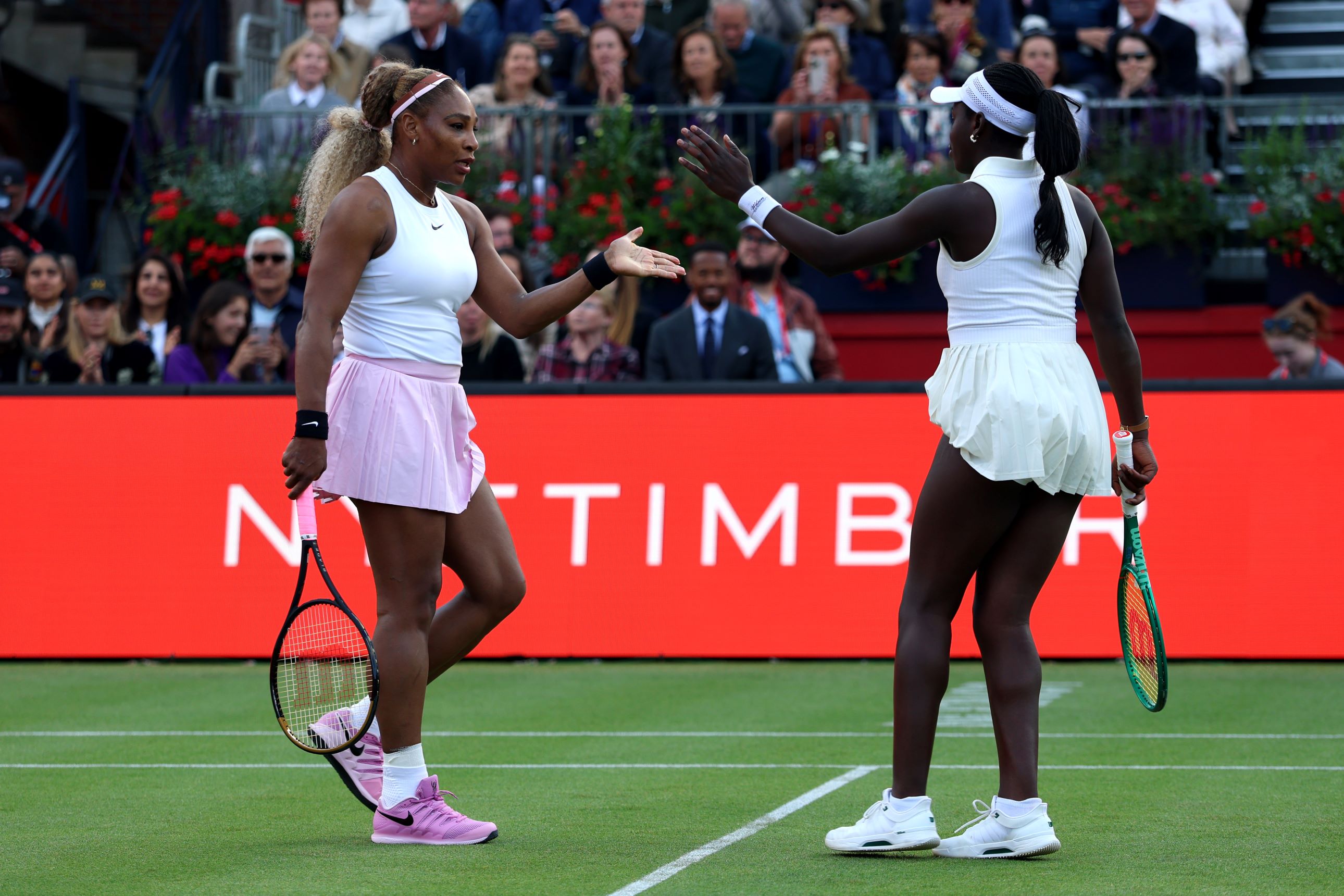 Tennis players Serena Williams and Victoria Mboko high five in celebration on the Andy Murray Arena in their round one match at the HSBC Championships
