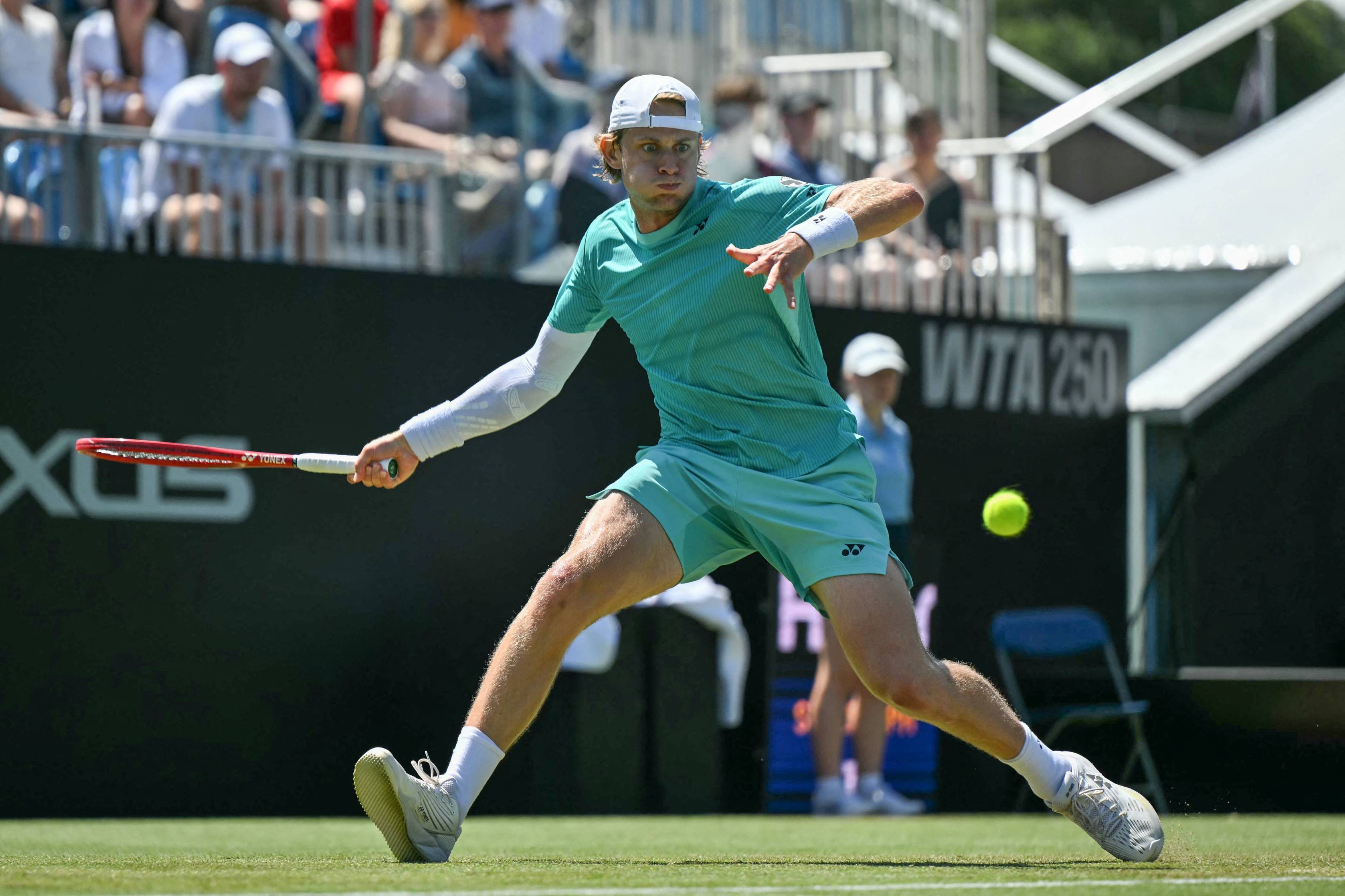 Zizou Bergs stretching to hit a forehand on court at the Lexus Eastbourne Open
