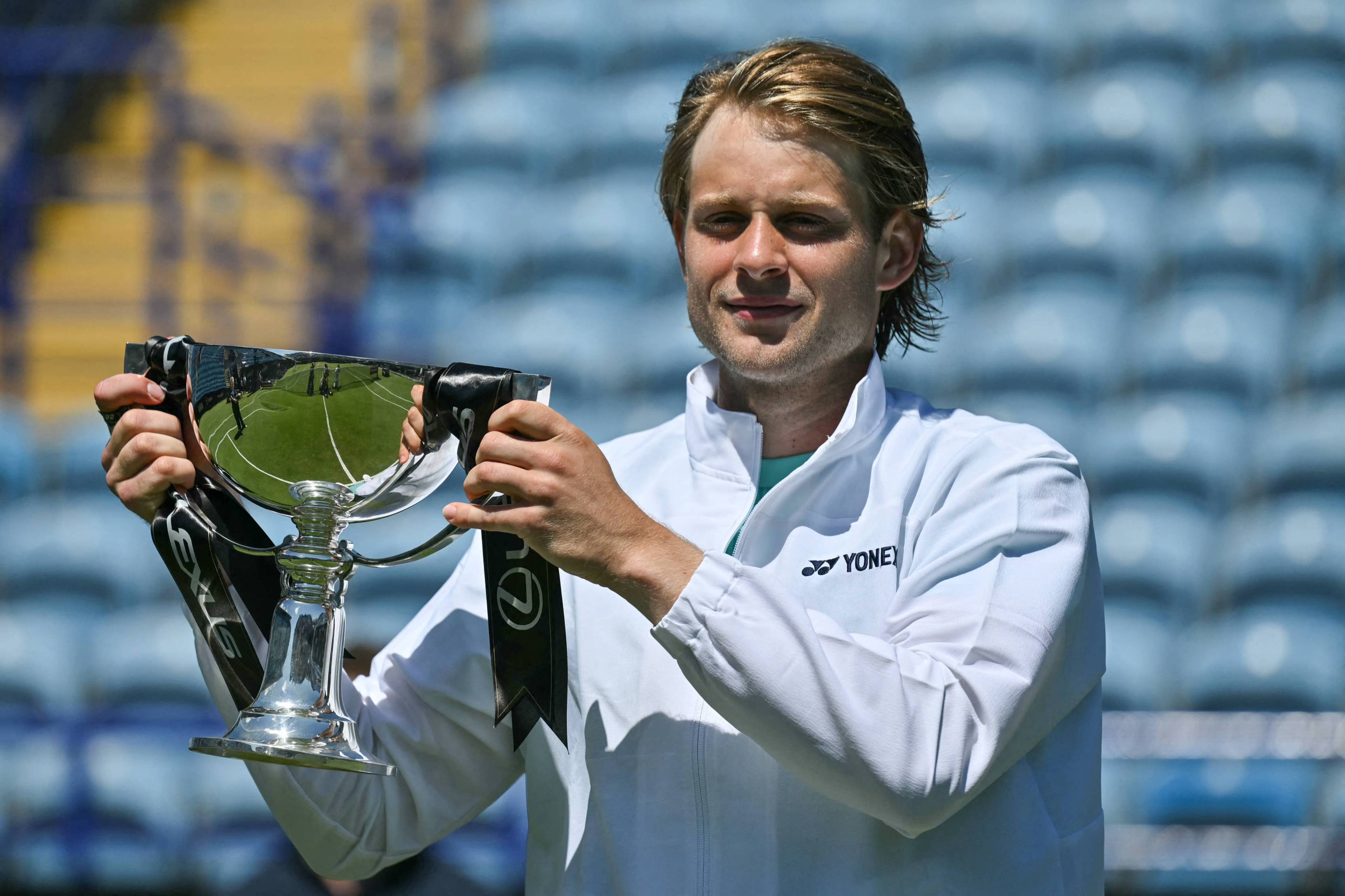 Zizou Bergs holding his trophy and smiling at the Lexus Eastbourne Open