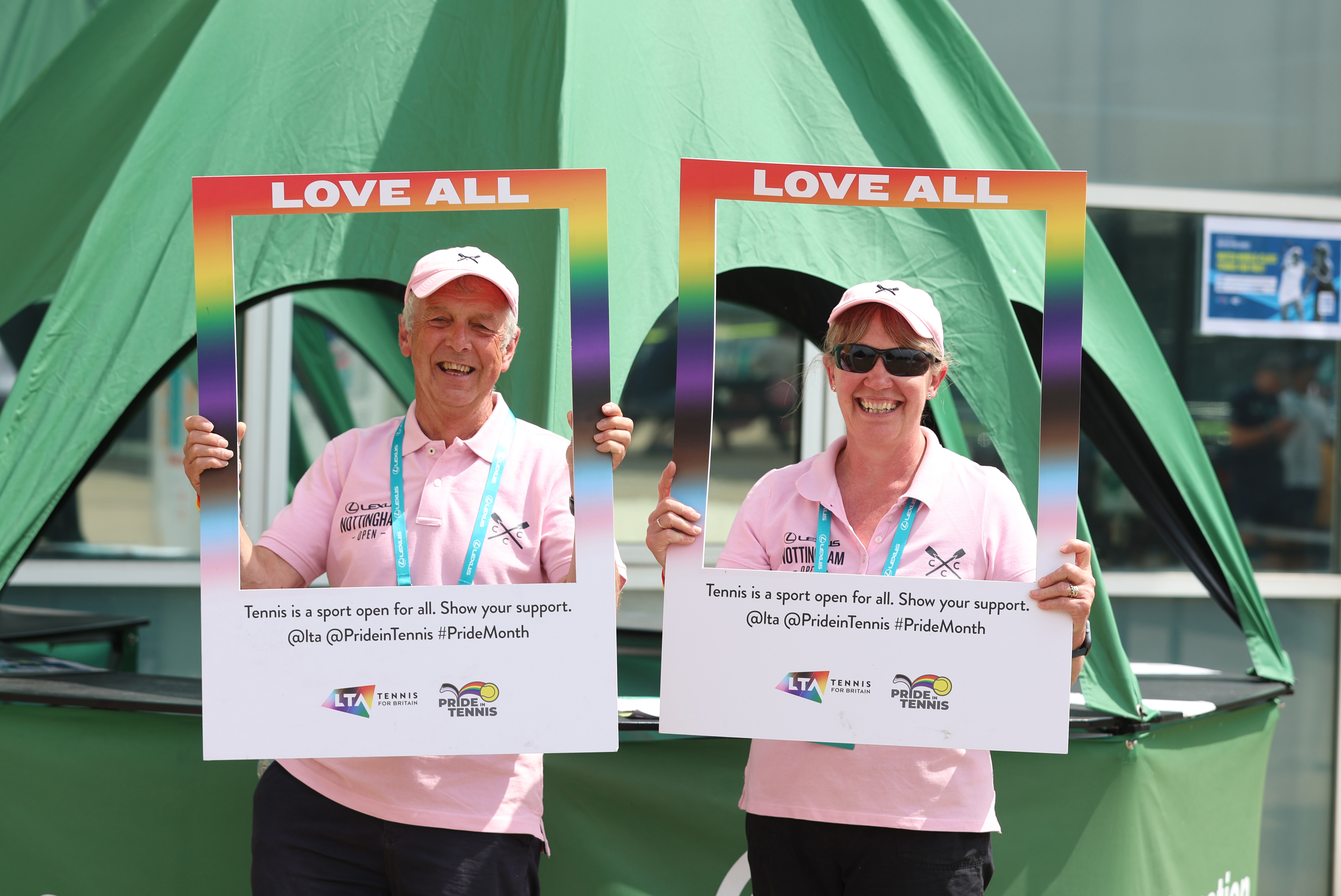 Two volunteers holding up a Love All sign