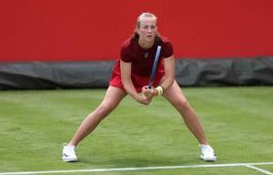 British tennis player Mika Stojsavljevic stood on a grass court while preparing to hit a return
