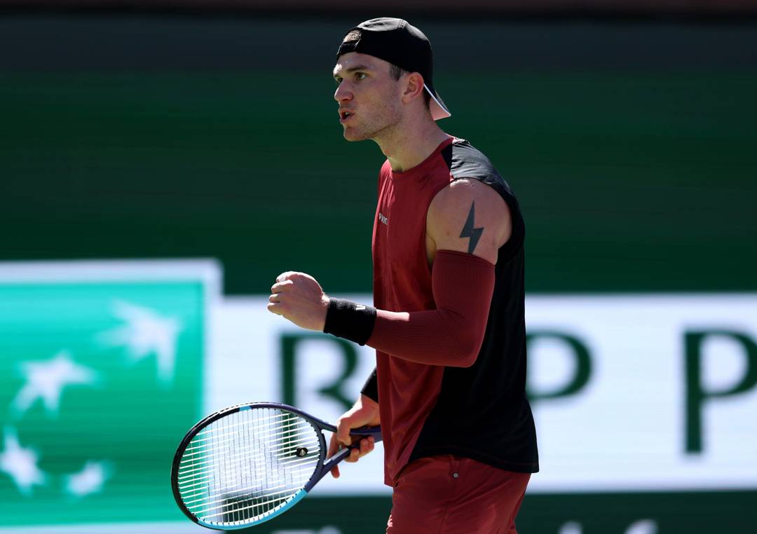 Jack Draper clenching his fist and holding a tennis racket in his other hand while on court at the BNP Paribas Open Indian Wells