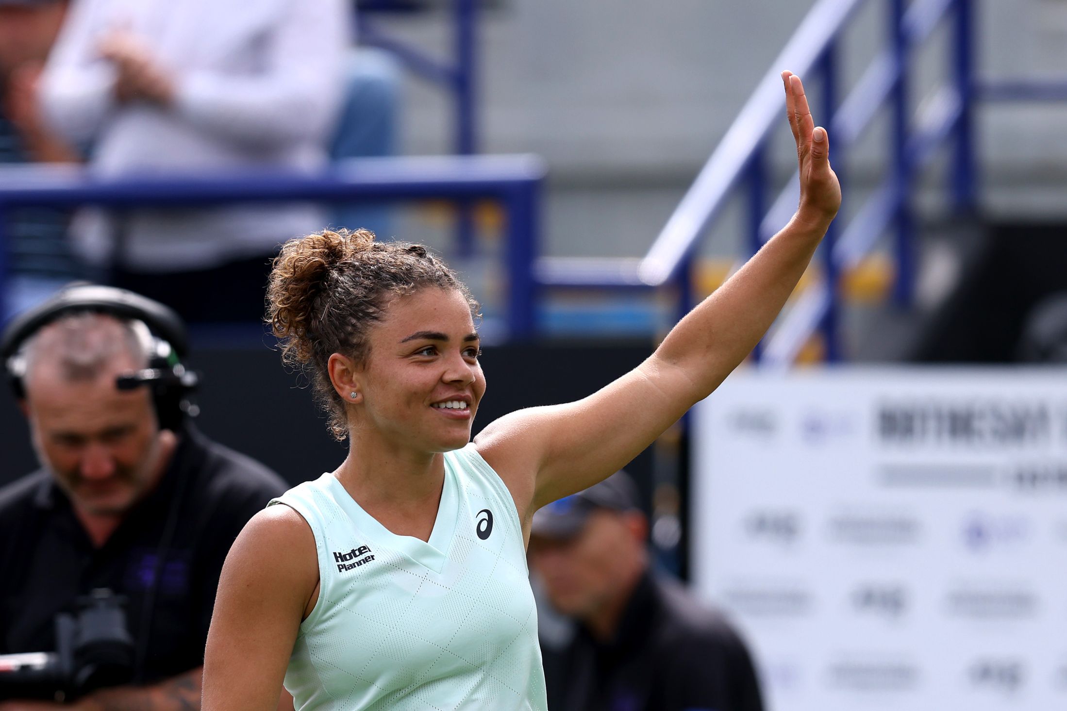 Italian tennis star Jasmine Paolini holding her hands up and waving to the crowd after winning at the Lexus Eastbourne Open