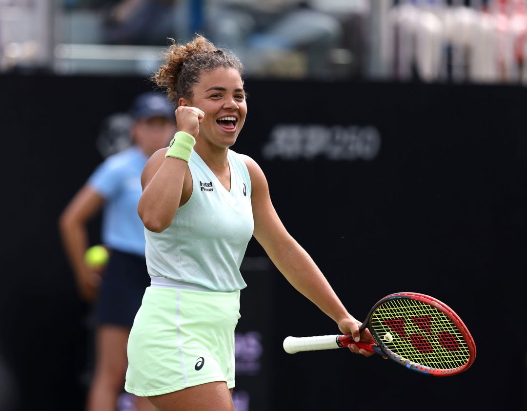 Italian tennis star Jasmine Paolini clenching her fist and smiling while holding her tennis racket on court at the Lexus Eastbourne Open
