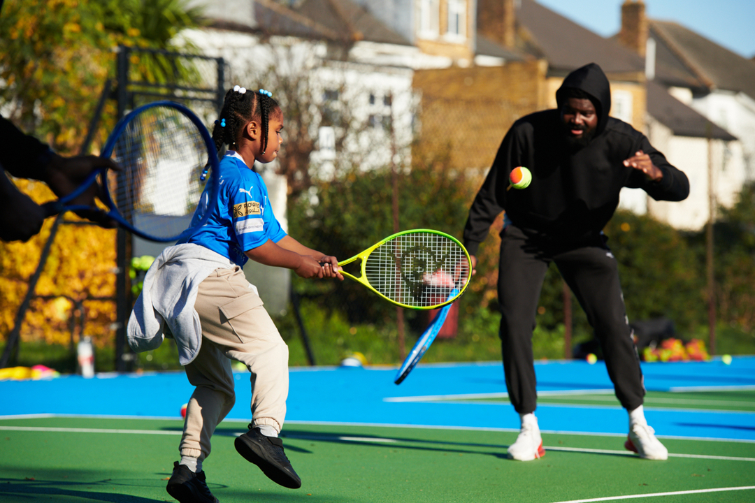 A young girl hitting a ball with a racket at a Free Park Tennis session