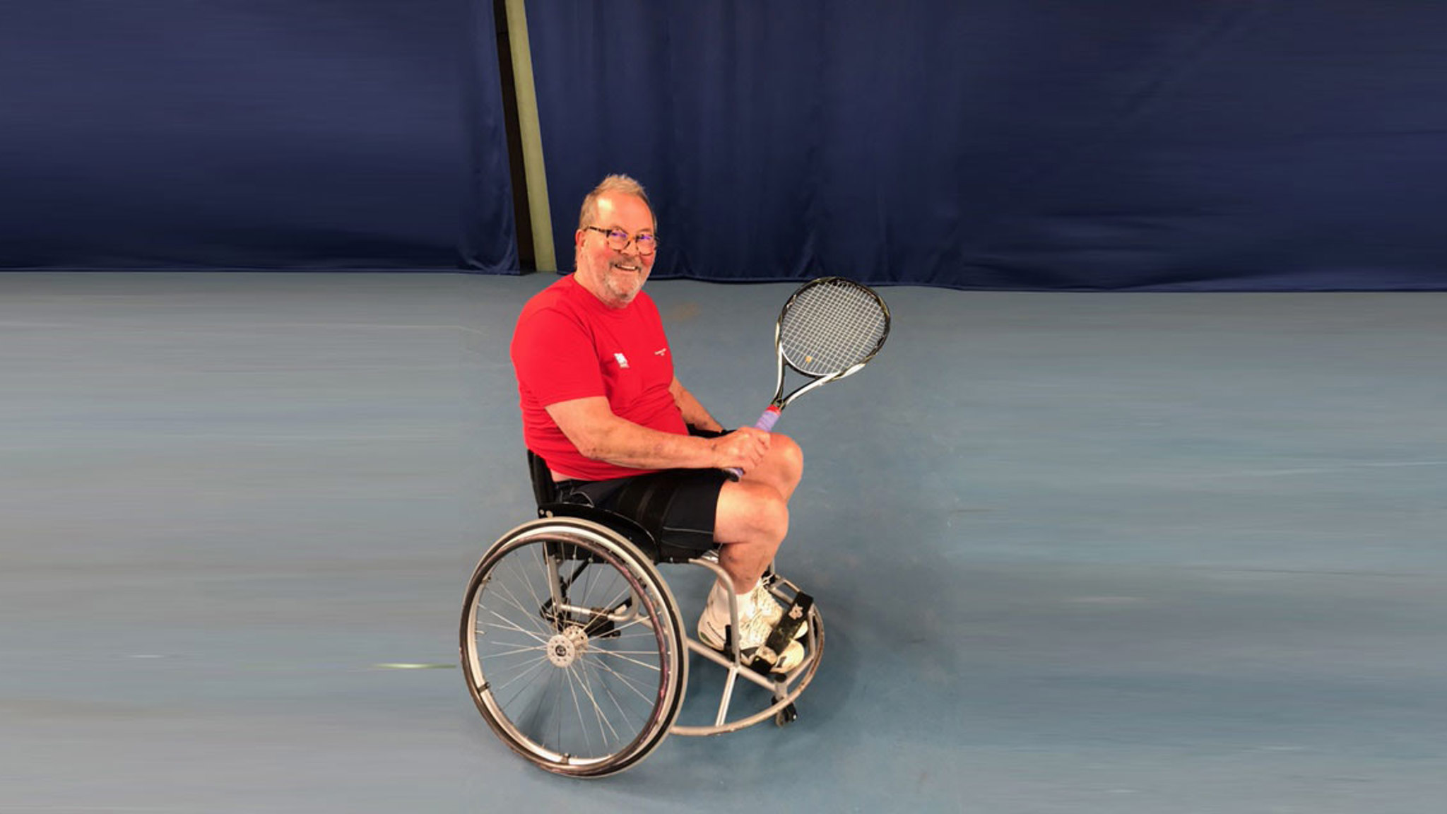 Steve Dargavel smiling and holding tennis racket