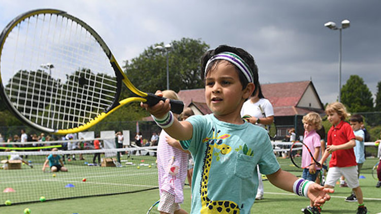 Young boy holding a tennis racket at the 'Middle Sunday' event