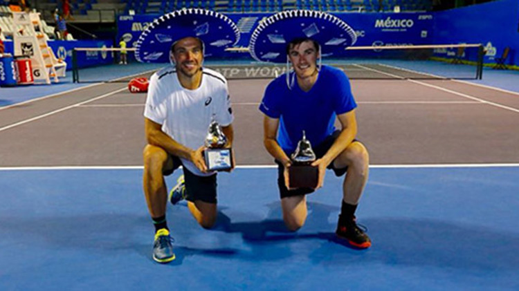 Jami Murray and Bruno Soares kneeling with their awards in hand on a tennis court