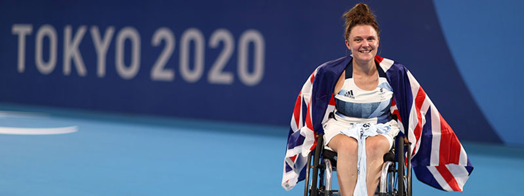 jordanne whiley on court with big GB flag around her