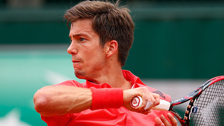 close up of aljaz beden following through with his racket after playing a forehand