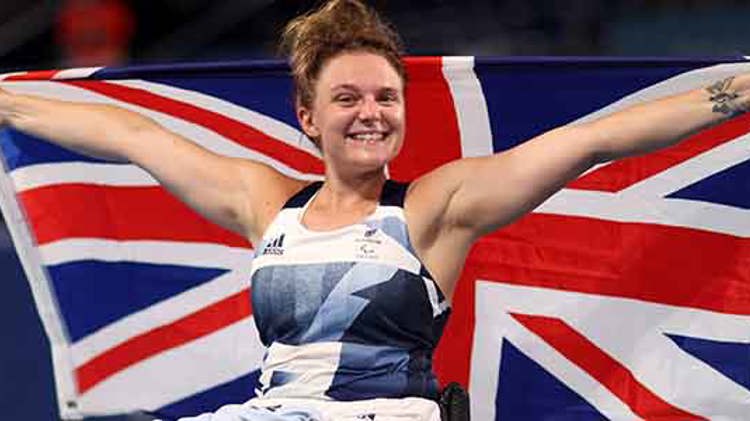 jordanne whiley celebrating holding up large GB flag behind her