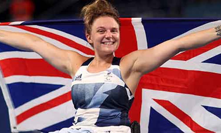 jordanne whiley celebrating holding up large GB flag behind her