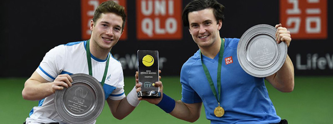Gordon Reid and Alfie Hewett with medal around their neck holding the ITF trophy