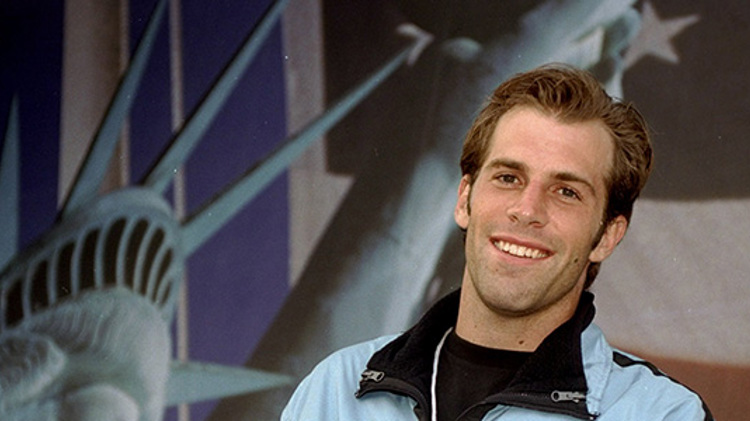 Greg Rusedski smiling with US flag in the background