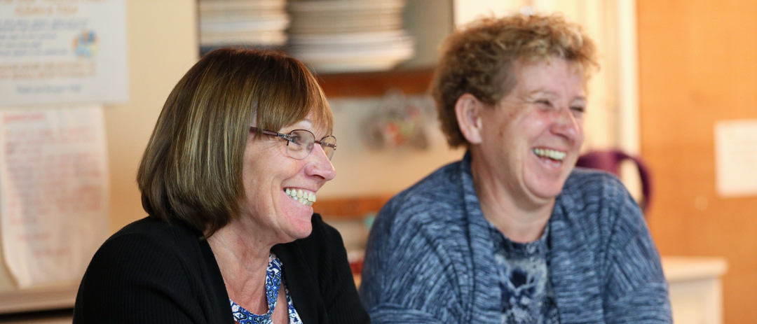 close up or caroline ratcliffe smiling sitting next to other committee member