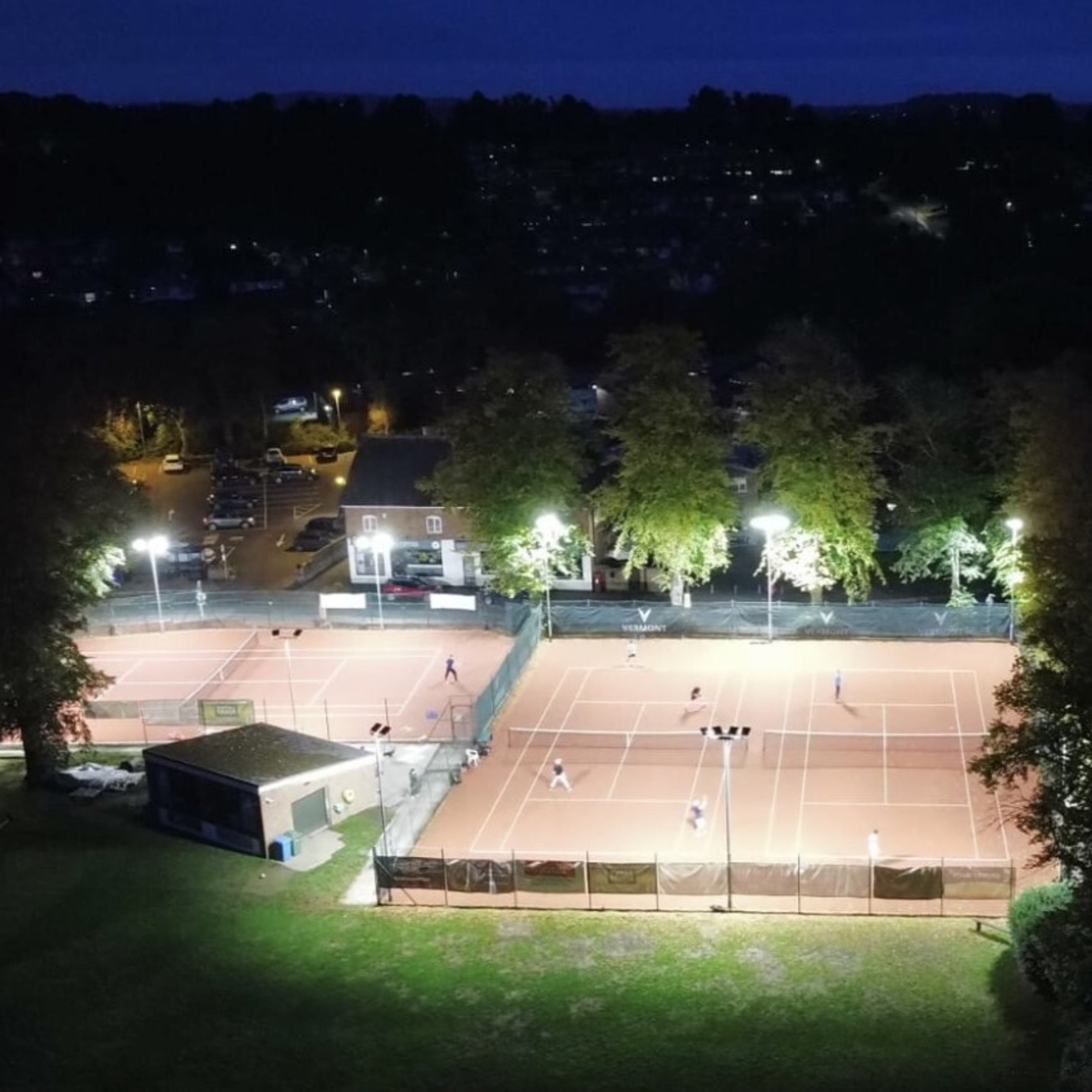 A birds eye view of Wombourne Tennis Club lit up by floodlights